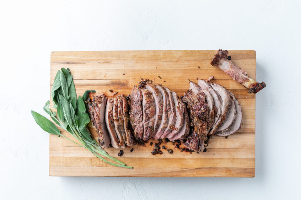 Sliced Roast and Herbs on a Cutting Board