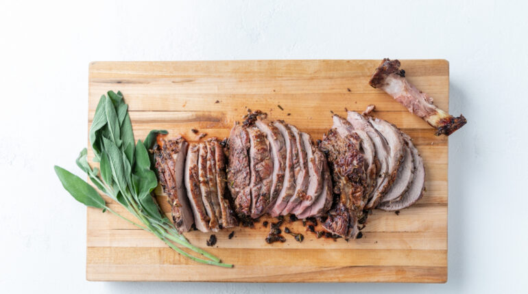 Sliced Roast and Herbs on a Cutting Board