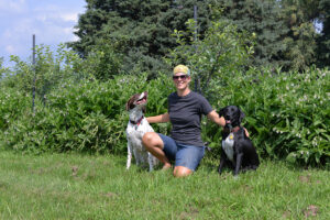 A Lakewinds Organic Field Fund Recipient Poses with Her Loyal Dogs
