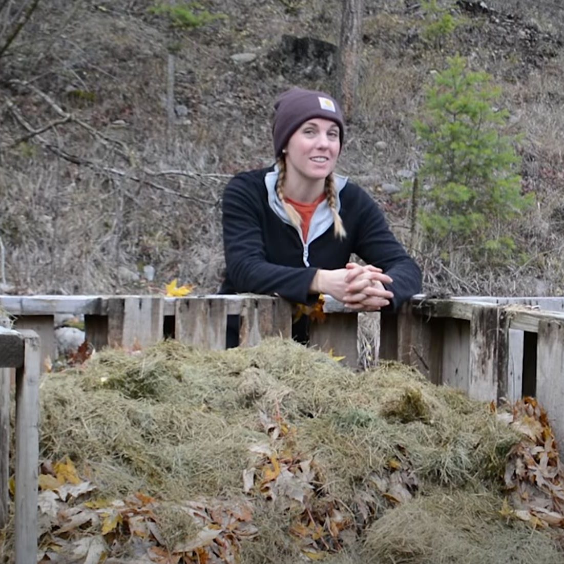 Farmer Leans Against the Fence of Her Compost Bin