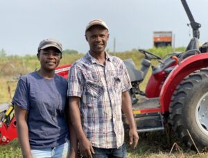 Farmers Lonah and Moses in Front of New Red Tractor