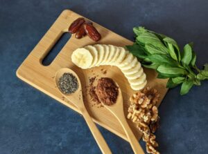 Protein Add-Ons Include Banana, Nuts, Chia Seeds, Mint, on a Cutting Board