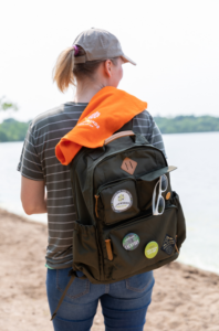 Person in Ballcap and Backpack Walks By a Lake