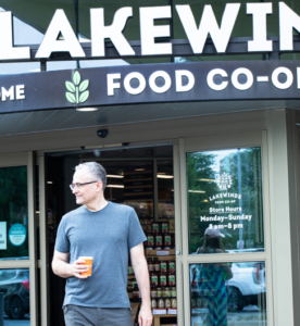 Customer Exits the Store Holding a Coffee To Go