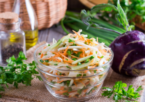 Kohlrabi Slaw in a Clear Bowl with Kohlrabi Bulb Nearby