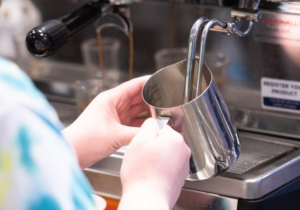 Barista Froths Foam for a Coffee Drink