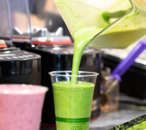 Organic Green Smoothie Poured from Blender Into To Go Cup