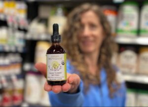 Woman Holding Bitters Out in Front of Her