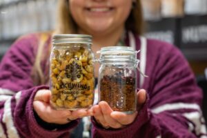 Employee Angel Holds Jars of Cashews and Berry Tea