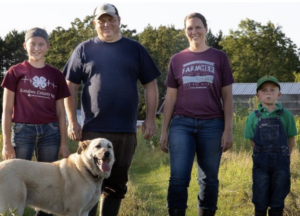 Family Stands In Farm Field