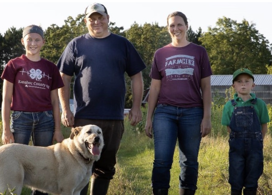 Family Stands In Farm Field