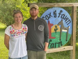 Farmer Tim and Spouse in Front of Fox and Farm Sign