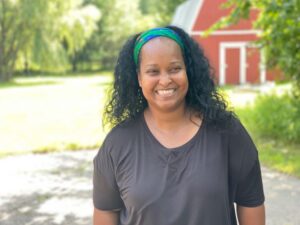 Naima Smiling in Front of Red Barn