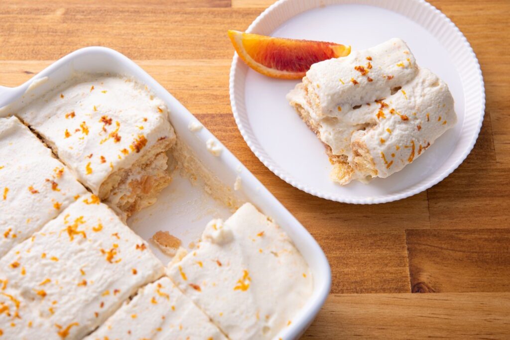 Baking Dish of Citrus Tiramisu with One Slice On a Plate