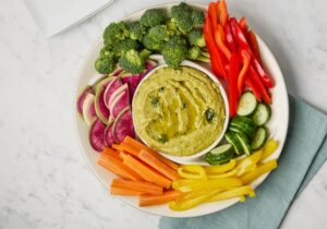 Herbed Hummus on a Platter Surrounded by Brightly Cut Vegetables