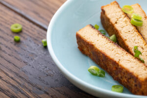 Crispy oven baked tofu slices on a blue plate