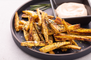Turnip fries on dark plate with aioli sauce