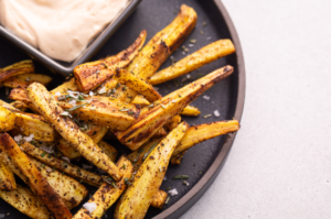 Turnip fries on dark plate with side of aioli