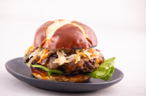 Grilled Cheeseburger with Kimchi on a Bun on a Dark Plate