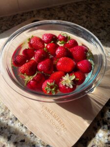 Strawberries in water solution on a wooden cutting board