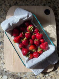 Strawberries on a towel in a glass container