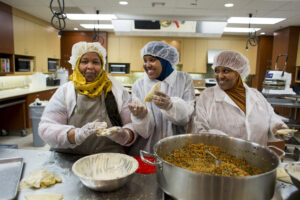 Three Women in Commercial Kitchen Making Sambusas